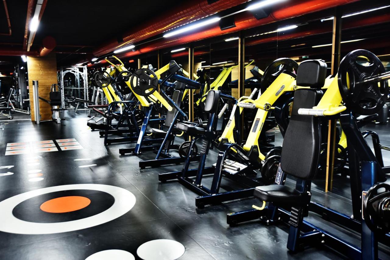 Dosso Dossi Hotels & Spa Downtown Estambul Exterior foto The photo shows a modern gym interior featuring various exercise machines. There are several yellow and black weight training machines aligned in rows, with a focus on strength training equipment. The flooring is dark with circular patterns, includin