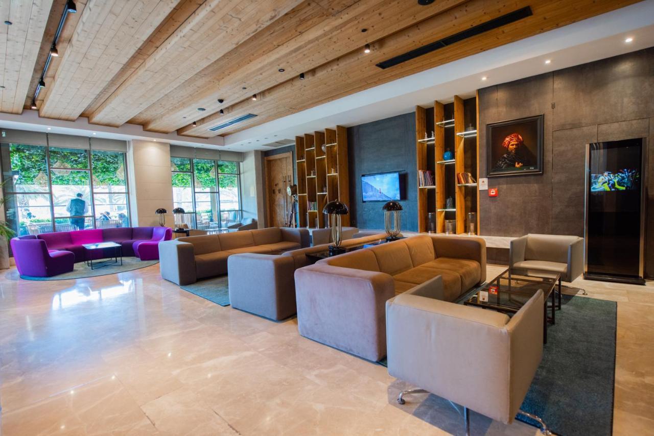 Dosso Dossi Hotels & Spa Downtown Estambul Exterior foto The photo shows a modern and stylish lobby area, featuring a combination of seating options. The space includes two large sofas in neutral colors, arranged around small glass tables. There are also individual armchairs and a more vibrant purple sofa 