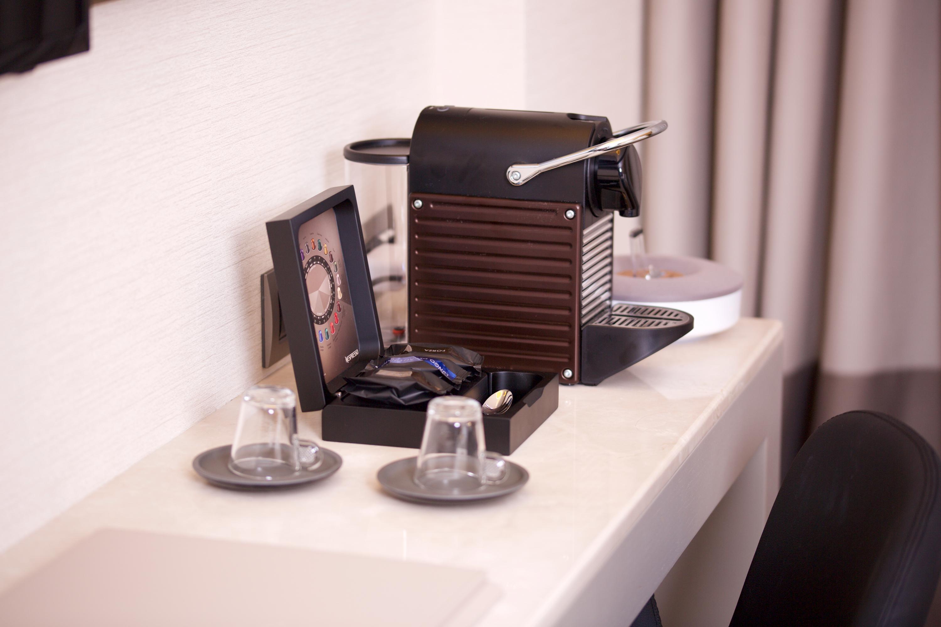 Dosso Dossi Hotels & Spa Downtown Estambul Exterior foto The photo shows a coffee machine placed on a light-colored countertop. The machine appears to be a Nespresso-style espresso maker, featuring a sleek, modern design in black. Next to the machine, there is a small decorative box containing coffee pods.