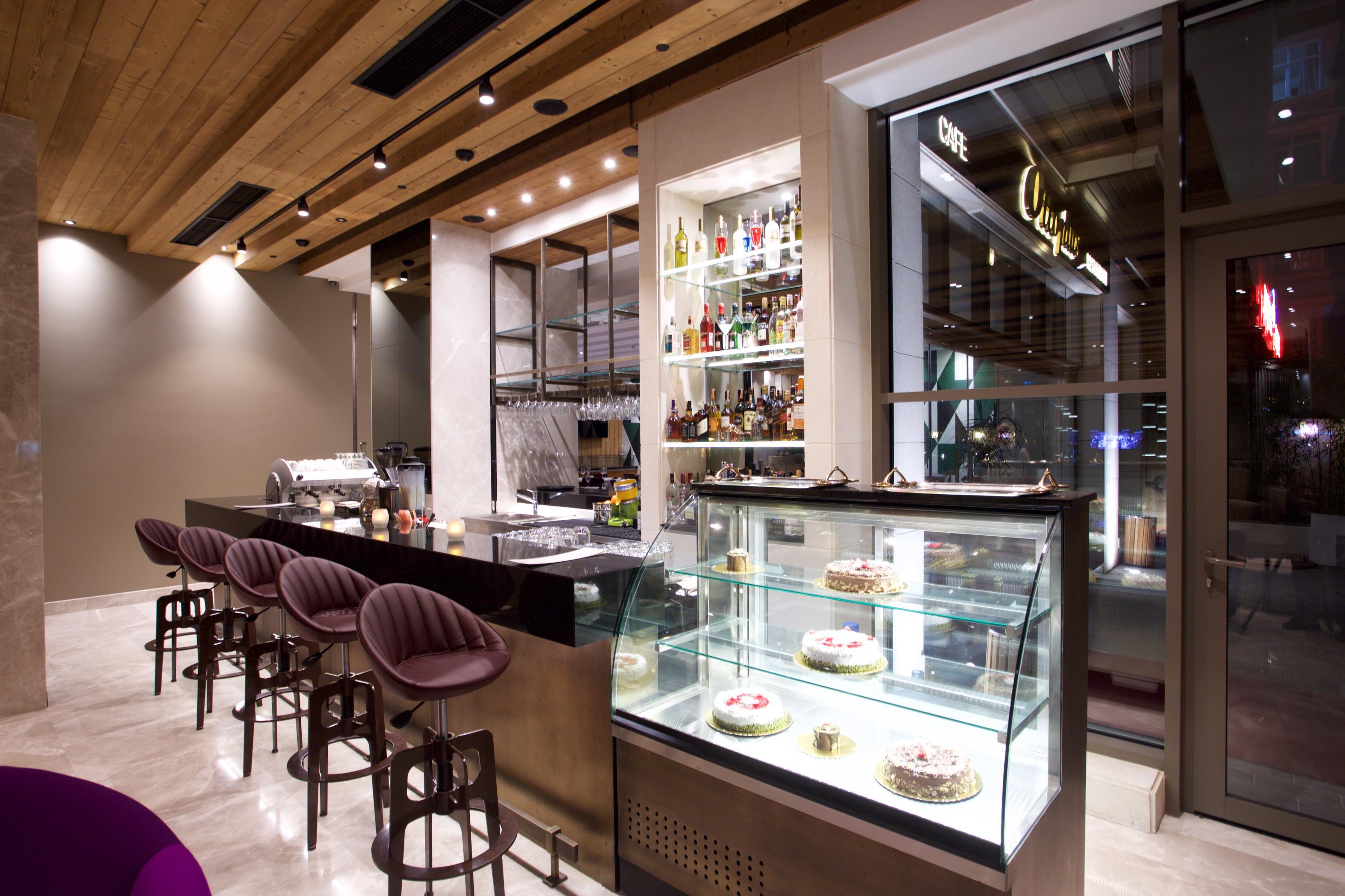 Dosso Dossi Hotels & Spa Downtown Estambul Exterior foto The photo shows the interior of a modern restaurant or café. There is a sleek bar area with a few high stools and a polished countertop. Behind the bar, shelves are stocked with various bottles, indicating a selection of drinks. To the right, there's