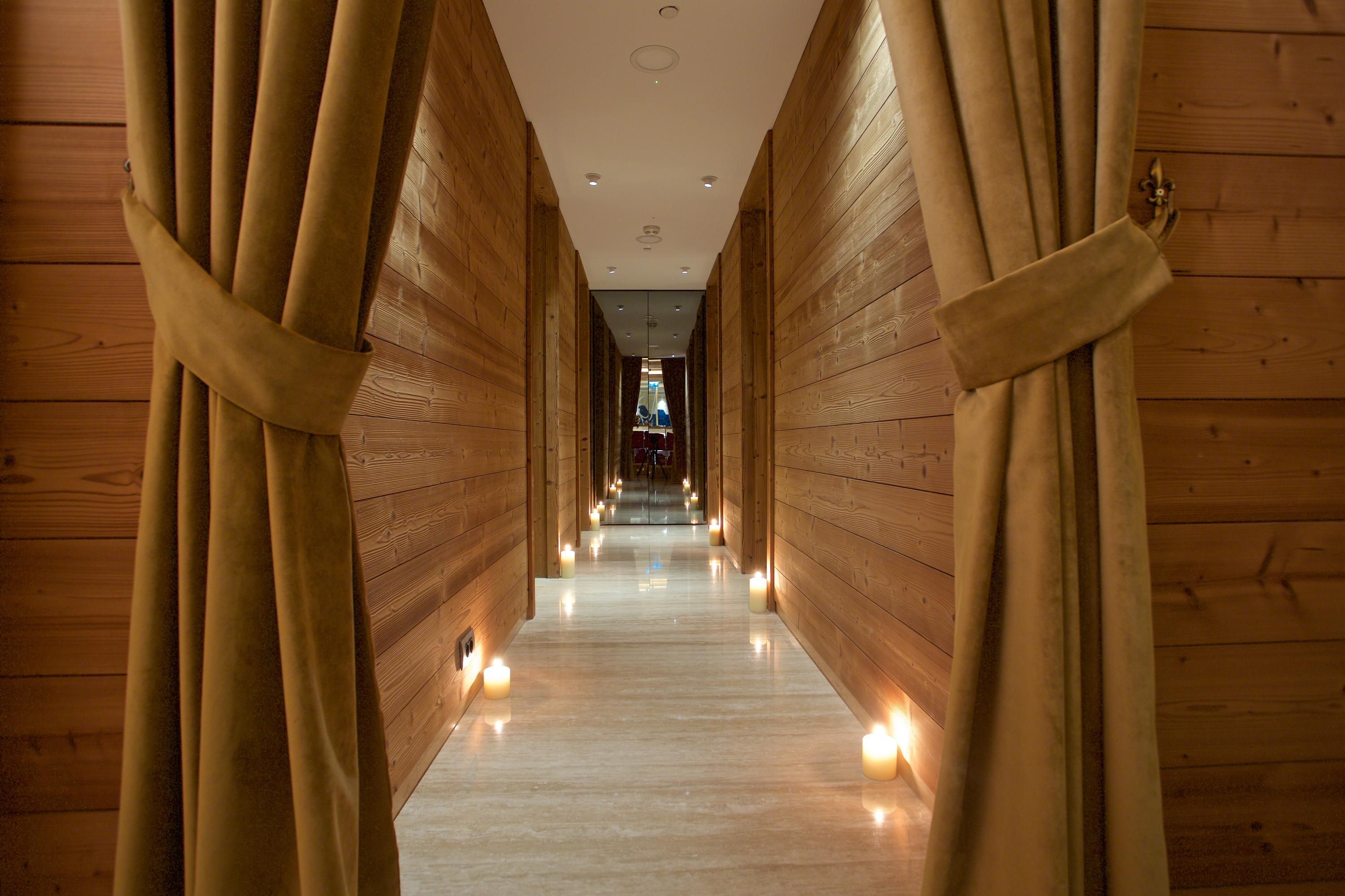 Dosso Dossi Hotels & Spa Downtown Estambul Exterior foto The photo shows a serene hallway with a modern aesthetic. The walls are made of wood, giving a warm and inviting feel. At the sides of the hallway, there are soft, draped curtains that add a touch of elegance. The floor is well-lit, primarily featuri