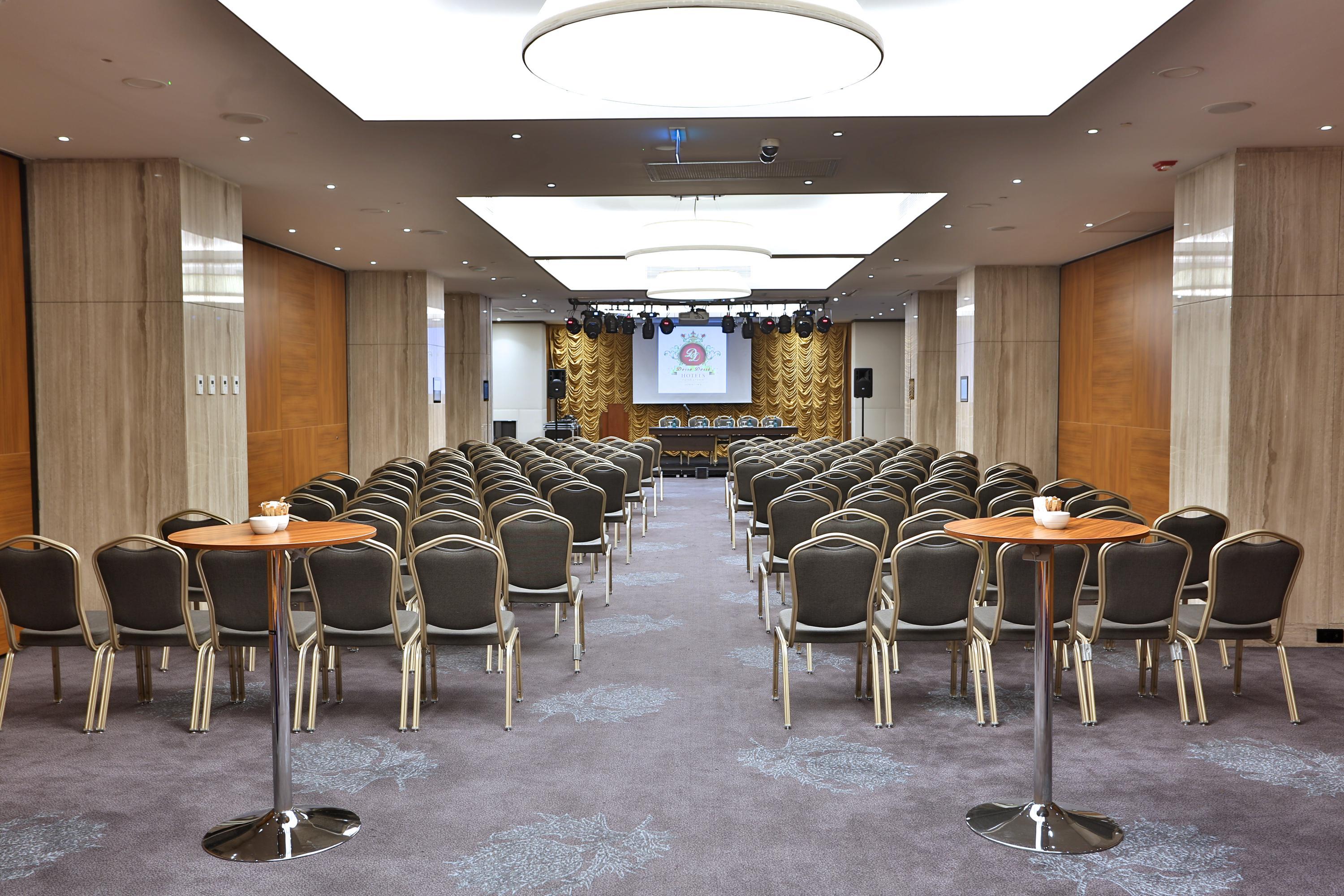 Dosso Dossi Hotels & Spa Downtown Estambul Exterior foto The photo shows a spacious meeting or conference room. There are many rows of chairs arranged in a theater-style setup, indicating that it's likely meant for presentations or lectures. In the front of the room, there is a stage or platform area with 