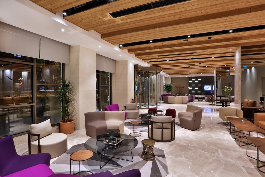 Dosso Dossi Hotels & Spa Downtown Estambul Exterior foto The photo shows a modern and stylish lobby or lounge area. It features a combination of comfortable seating options, including a mix of chairs and sofas in various shapes and colors, such as purple and beige. The space is well-lit with natural light 